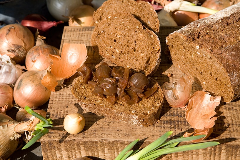 Confituur van uien op een sneetje brood op een plank